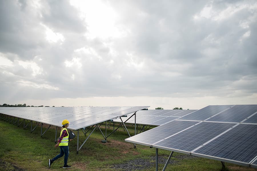 Worker inspecting a solar panel installation